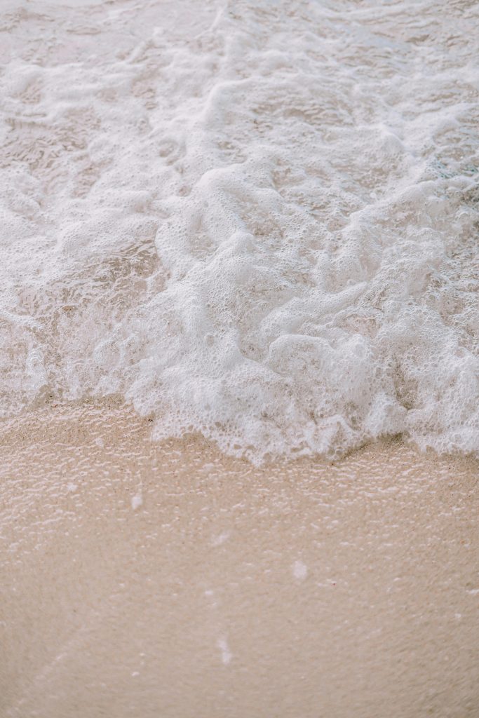 Close-up of soft white beach sand with gentle waves lapping at the shore of Panglao Island